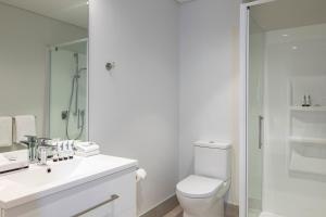 a bathroom with a toilet and a sink and a shower at Quest Mount Eden in Auckland