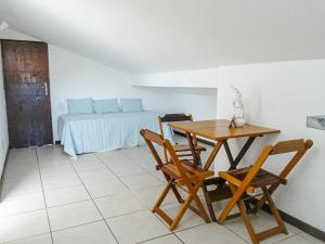 a dining room with a table and chairs and a bed at Viva Buzios in Búzios
