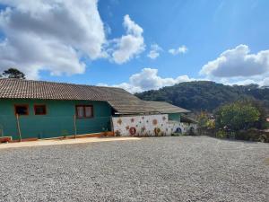 a house with a gravel driveway in front of it at Chalés Encantos de Cunha Verde in Cunha