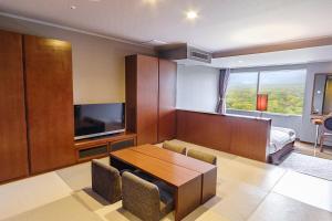 a room with a table and a tv and a bedroom at Hotel Epinard Nasu in Nasu