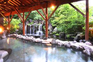 una piscina con cascada en un jardín en Hotel Epinard Nasu en Nasu