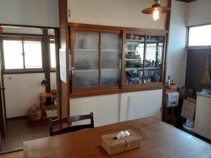 a dining room with a table and some windows at Hallelujah in Morohongō
