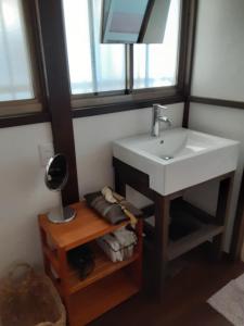 y baño con lavabo y espejo. en Hallelujah, en Morohongō