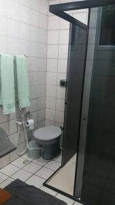 uma casa de banho com um WC e um chuveiro com toalhas em Estiloso 2 Quartos Wifi e SmarTV em Guarapari
