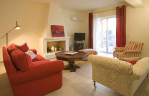 a living room with a red couch and chairs and a fireplace at Villa Ares with private pool and a spectacular seaview 150m from the beach in Istron