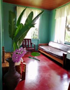 a living room with a bed and a vase with flowers at Casita el jardin in Bijagua
