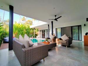 sala de estar con muebles y piscina en Villa Ataya, en Lovina