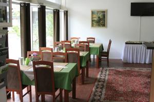 ein Esszimmer mit grünen Tischen und Stühlen in der Unterkunft Hotel Mettmann in Mettmann