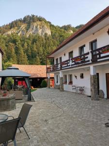 a courtyard of a building with a mountain in the background at Guest House Piatra Craiului in Bran