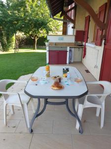 - une table et des chaises blanches sur la terrasse dans l'établissement Au Grés du Vent, à Ruy