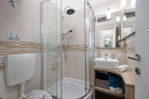 a bathroom with a shower and a toilet and a sink at Naval apartment in Rijeka +27 photos