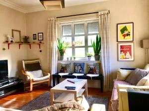 salon z kanapą, stołem i oknem w obiekcie Antas Cozy House w Porto