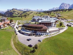 una vista aerea di un grande edificio in un campo di Piccolo Hotel Sciliar ad Alpe di Siusi