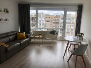 a living room with a couch and a large window at Studio Ostend Living in Ostend
