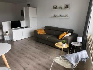 een woonkamer met een bank en een tafel bij Studio Ostend Living in Oostende