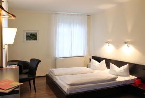 a bedroom with a bed and a chair and a window at Von Korff´S Rest & Relax Hotel in Meschede