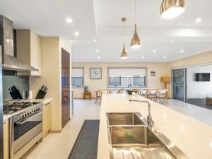 an open kitchen and living room with a large island in a house at Gather at Vincentia in Vincentia