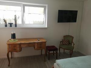 een kamer met een bureau, een stoel en een raam bij Ferienwohnungen Elsen in Schwebheim