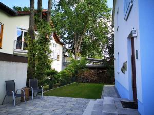 een huis met een tuin met twee stoelen en een gazon bij Ferienwohnungen Elsen in Schwebheim