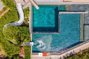 una vista aérea de una piscina con tobogán de agua en Sunsuri Phuket - SHA Plus en Nai Harn Beach