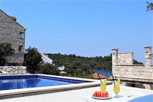 two drinks on a table next to a swimming pool at Corallium Blue in Pomena