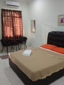 um quarto com uma cama, um sofá e uma mesa em Faris's Homestay & Resort em Pasir Puteh