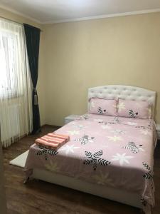 a bedroom with a pink bed with pink and white sheets at Casa de vacanță Dalia și Crina in Babadau