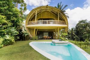 a round house with a pool and a balcony at Eco Six Bali in Tampaksiring