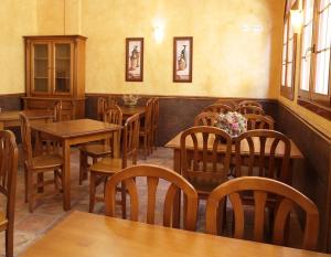 a dining room with wooden tables and chairs at Hostal Villa de Navarrete in Navarrete