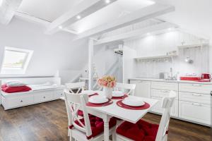 a white kitchen with a white table and chairs at Penzion Belle Donne in Znojmo