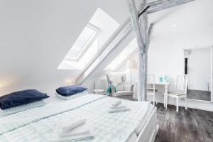 a white bedroom with a bed and a desk at Penzion Belle Donne in Znojmo