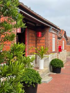 una casa de ladrillo con plantas delante de ella en 金門古寧歇心苑官宅古厝民宿 Guning Xiexinyuan Historical Inn en Jinning