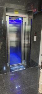 a bathroom with a shower with a blue glass door at Venster Residency in Chennai