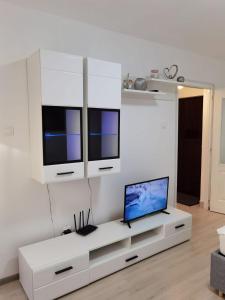 een woonkamer met een tv aan een witte muur bij Focus Hun in Miercurea-Ciuc