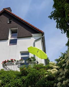 a green umbrella sitting on a balcony of a house at Ferienwohnung am Wall in Soest