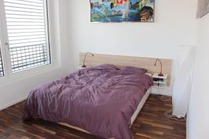 a bedroom with a purple bed and a window at Beautiful Loft In The Center Of Lausanne in Lausanne
