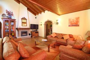 a living room with couches and a table and a fireplace at Casa Bruella - Walk to beach Pool WiFi and BBQ in Carvoeiro