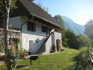 una casa blanca con una parrilla delante en Holiday Home Natura, en Bovec