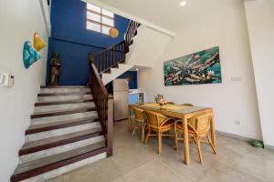 a dining room with a table and a staircase at Villa Padi Karo in Canggu