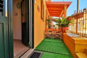 una puerta abierta a un balcón con suelo verde en Casa Shardana en Iglesias