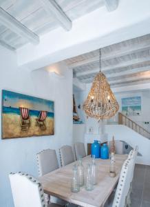 ein Esszimmer mit einem Tisch, Stühlen und einem Kronleuchter in der Unterkunft Deluxe Paros Villa Grand Villa Sea View Private Pool 4 BDR Tserdakia in Kampos Paros
