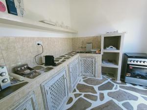 a kitchen with a counter top and a stove at Neverland Watamu Villas in Watamu