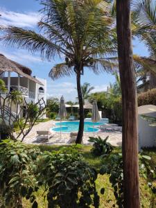a resort with a pool and palm trees at Watamu Neverland Villas in Watamu