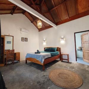 a bedroom with a bed and a mirror and a rug at Kambuna Bungalow in Krui