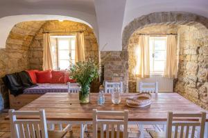 uma sala de jantar com uma mesa de madeira e um sofá em Old smithery from 17. century em Sobčice