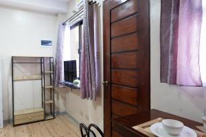 ドゥマゲテにあるLuis miguel's placeの木製のドアとテーブルが備わる小さな客室です。
