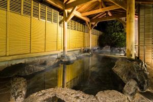a pool of water in a building with rocks at Hakone Yumoto Onsen Hotel Kajikaso in Hakone