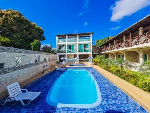 a swimming pool in the backyard of a house at Village Encantado in Guarajuba