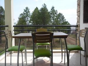 a table and chairs on a balcony with a window at Pinares de Colon in Colón