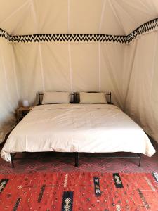 a bedroom with a bed in a tent at Bivouac Erg Chegaga Nomademoi in El Gouera